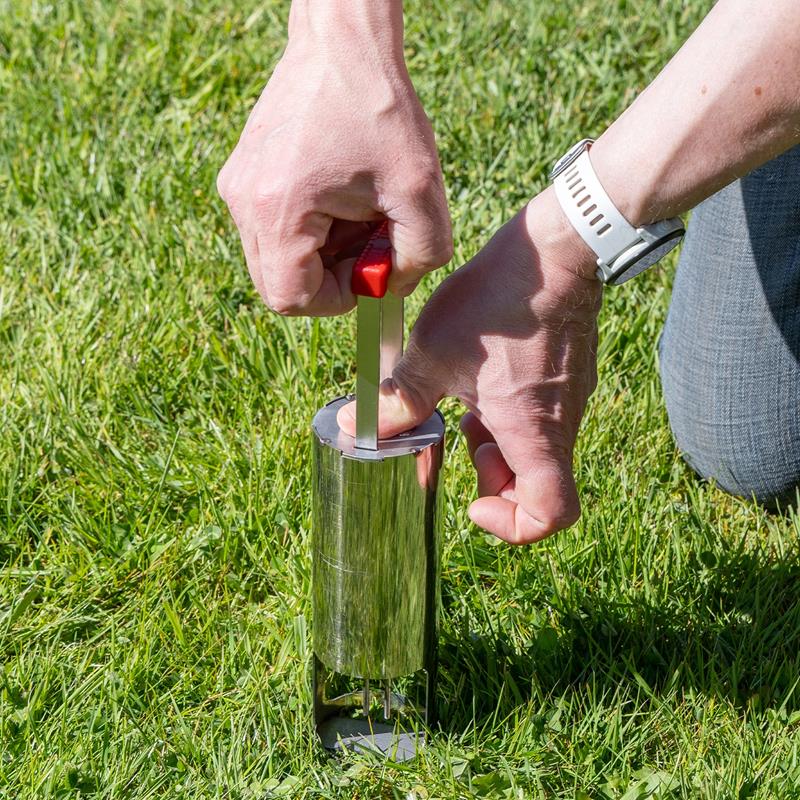 Großansicht der Bildergalerie Eine Person entnimmt mit dem VOSS.garden VoleEX Premium Edelstahlwerkzeug eine Bodenprobe vom Rasen.