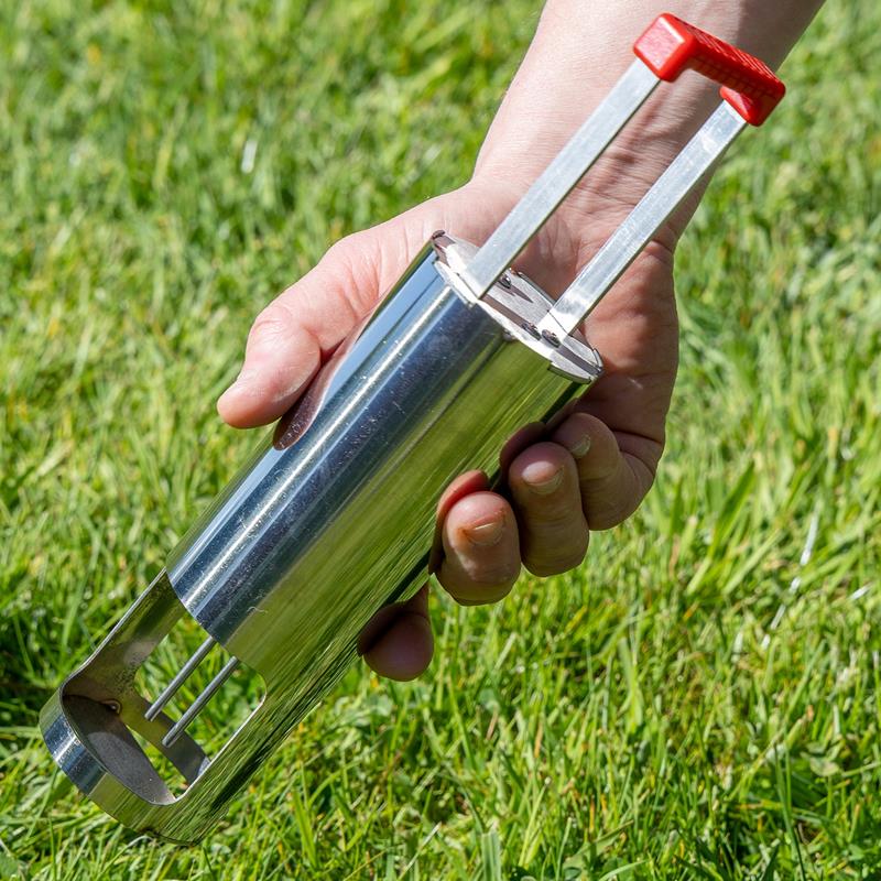 Großansicht der Bildergalerie Eine Hand hält die VOSS.garden VoleEX Premium Wühlmausfalle Edelstahl von VOSS.garden über grünes Gras.