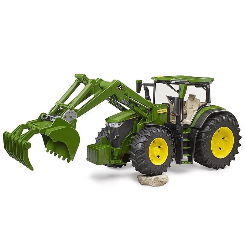 Der BRUDER John Deere 7R 350 Traktor mit Frontlader (1:16, ab 3 Jahren) in grün mit schwarzen-gelben Rädern und aufklappbarer Motorhaube und Türen ist auf einem Felsen abgebildet. Das linke Vorderrad über einen Stein fährt.