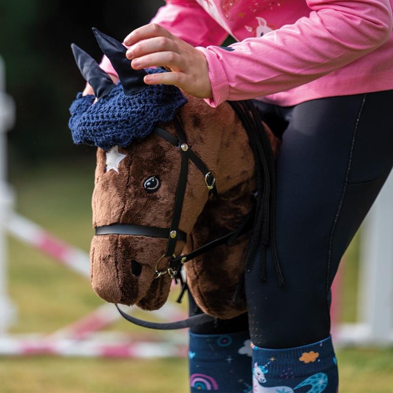 Großansicht der Bildergalerie Ein Kind im Freien hält ein braunes Steckenpferd und trägt bunte Leggings, Stiefel und die HKM Fliegenmütze für Steckenpferd in Dunkelblau von HKM.