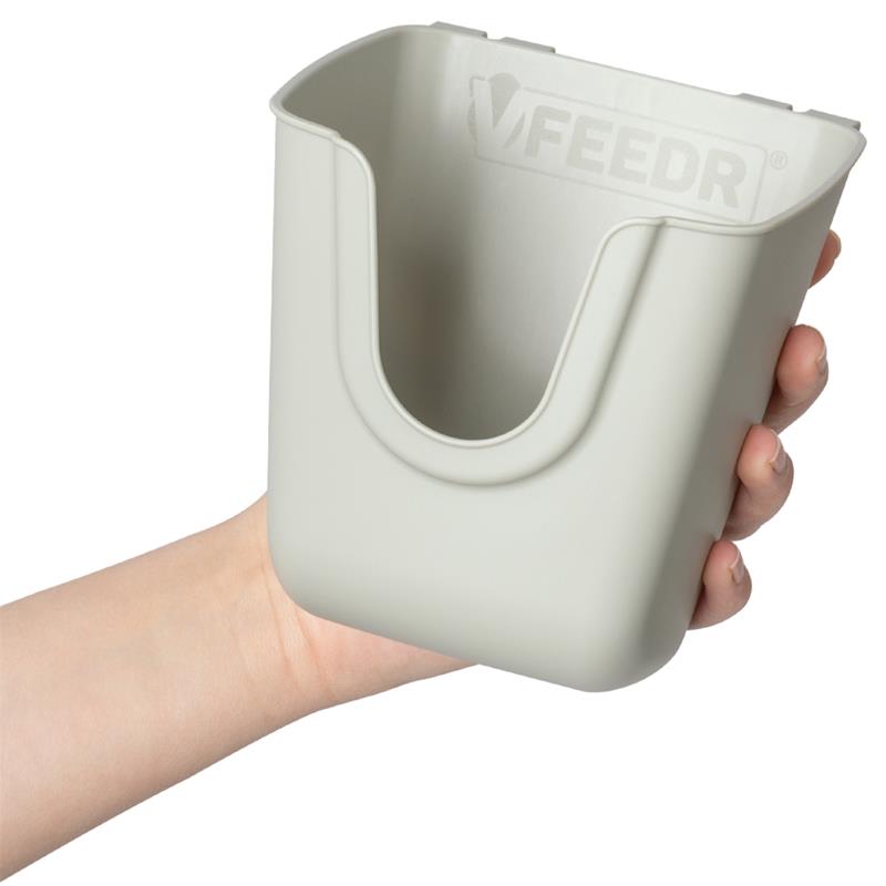 Großansicht der Bildergalerie Eine Hand hält einen hellgrauen Geflügel Futterbecher 400 ml – 350 g, V-Feedr V-Form Behälter mit einer gebogenen Öffnung an der Oberseite.